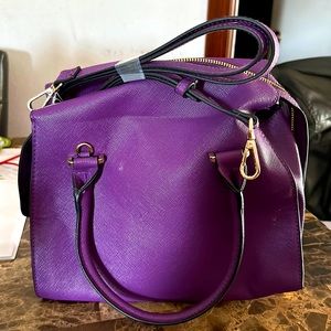 Purple new day handbag with two inside pockets and shoulder strap as well.